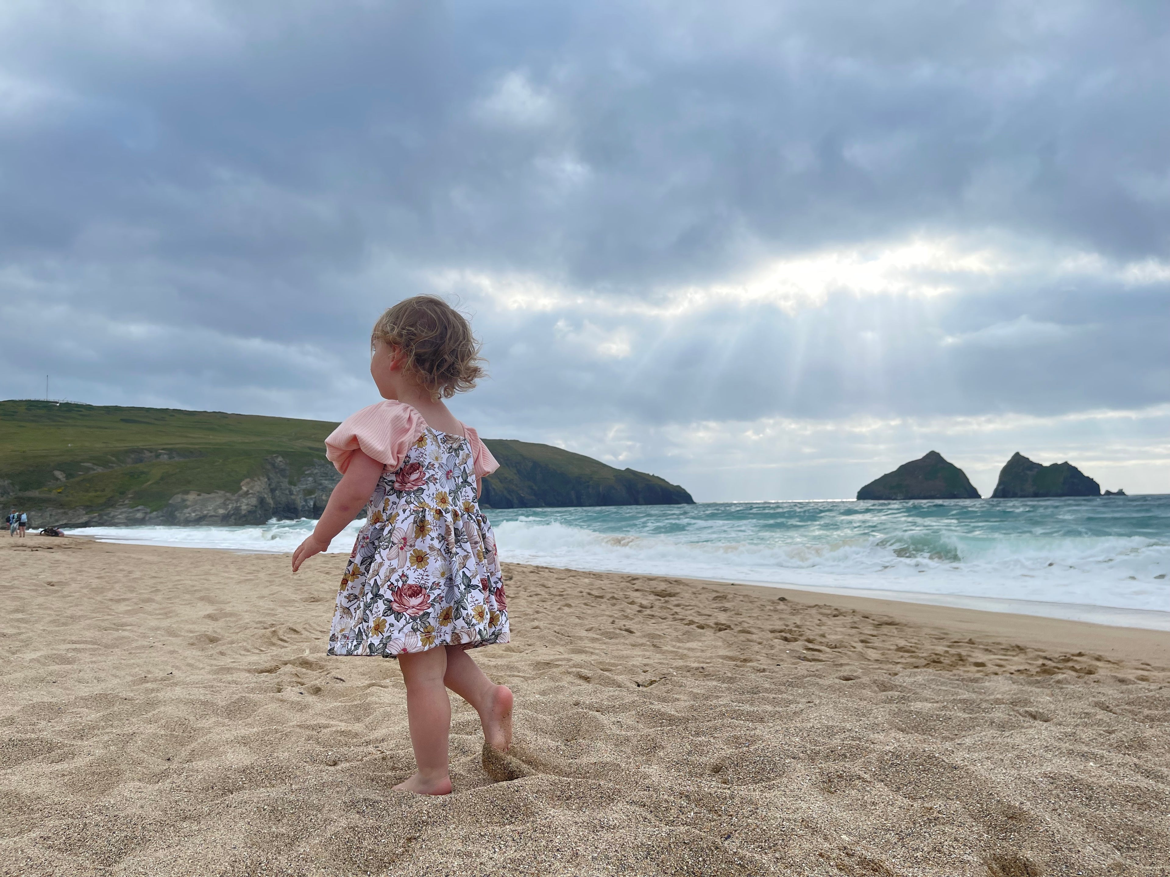 Child wearing puff sleeved dress on a beach